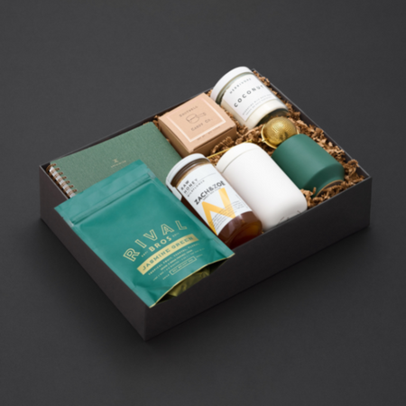 luxe gift box full of green products on a black background