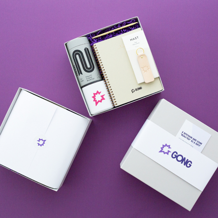 three branded corporate gift boxes on a purple background