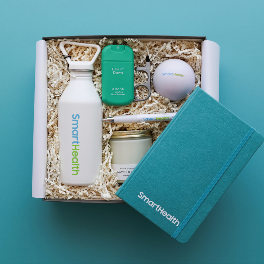 white smart health water bottle with teal branded notebook and other swag